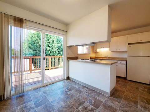 A kitchen with a white counter and brown tiles.