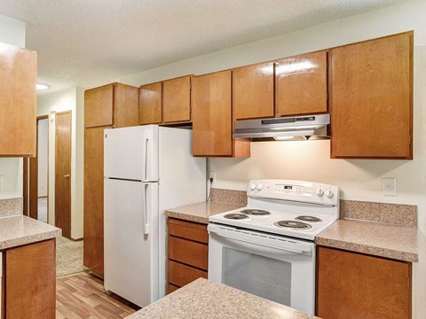a kitchen with white appliances and wooden cabinets