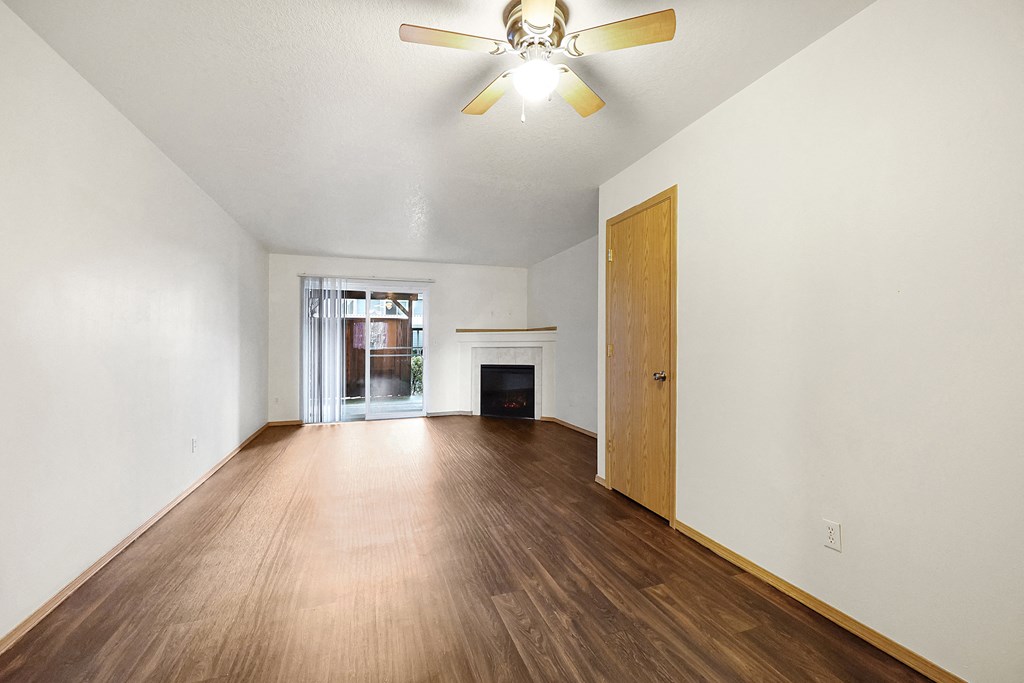 a living room with hardwood floors and fireplace