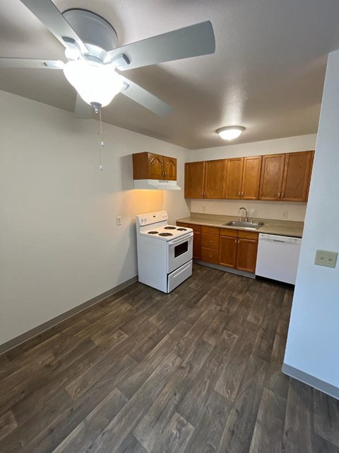 a kitchen with a white stove and a ceiling fan
