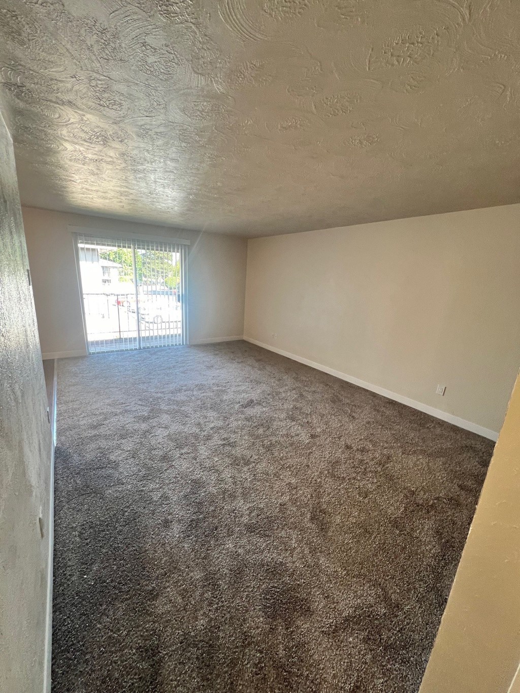 A room with a carpeted floor and a window.
