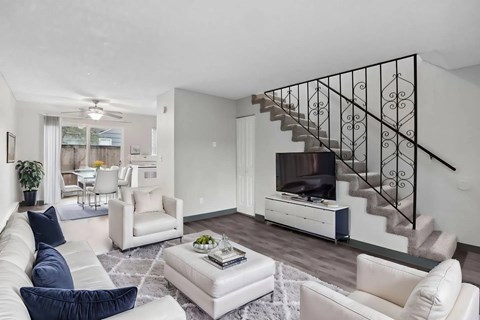 A living room with a staircase and a television.
