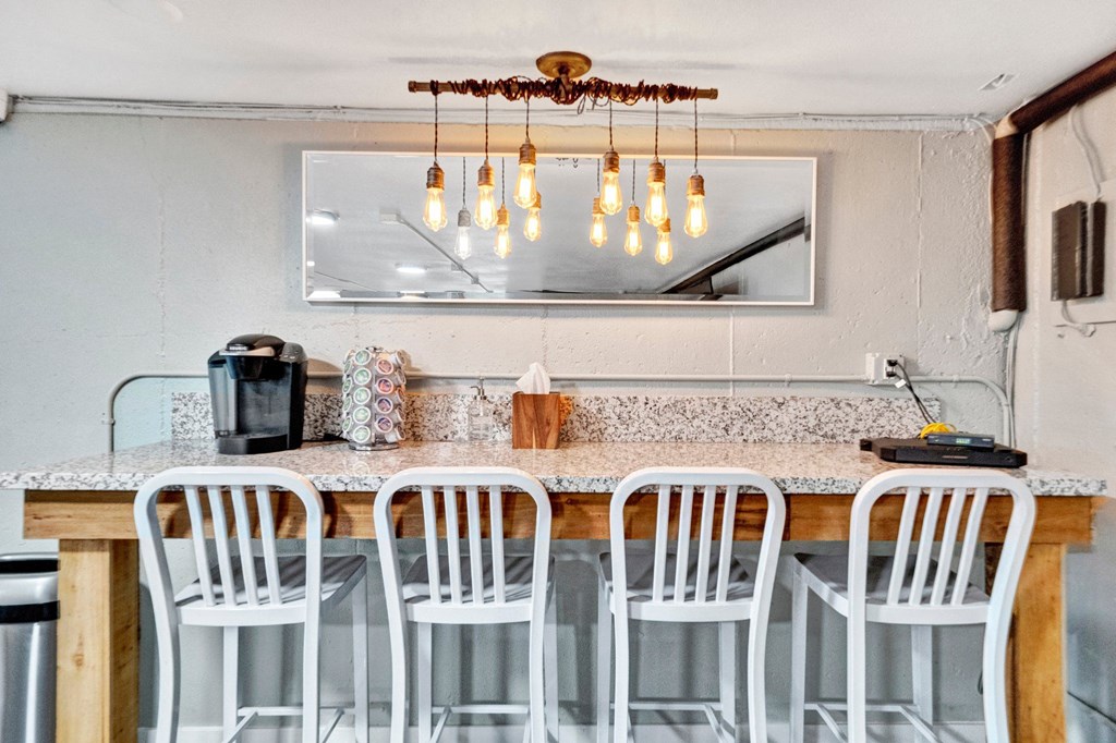 a kitchen with a long counter and white chairs Sunset Station Apartments Portland Oregon 