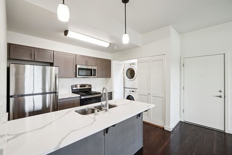 A modern kitchen with a stainless steel refrigerator and a white countertop.