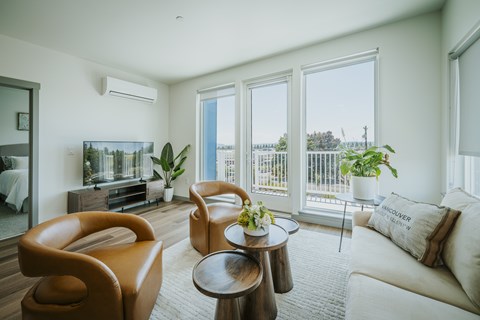 A living room with a brown leather chair and a white couch.