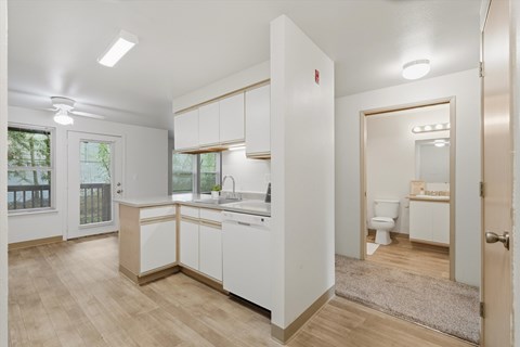 A kitchen with white cabinets and a sink.