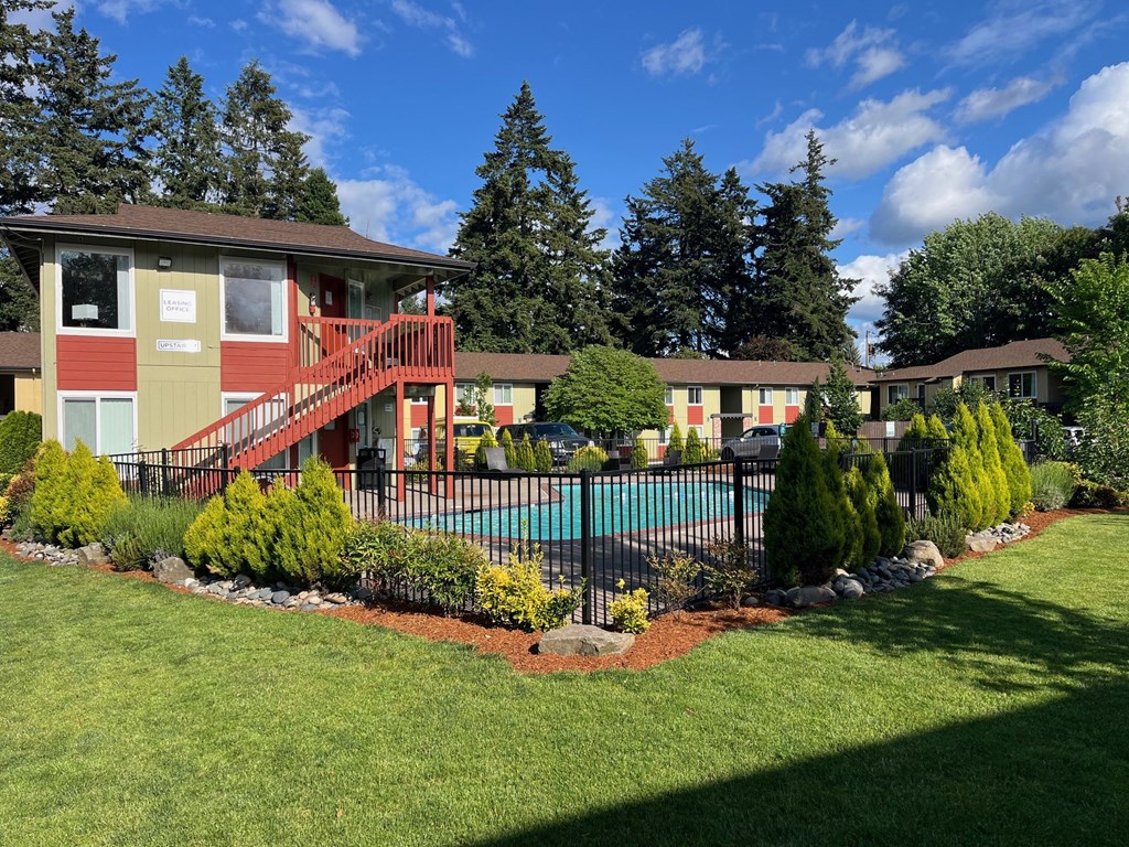 a yard with a pool and a house with a fence