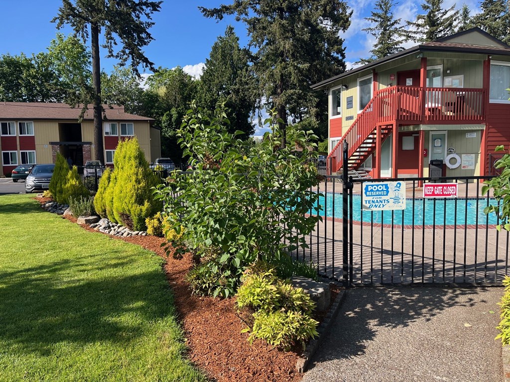 a house with a pool and a fence in front of it