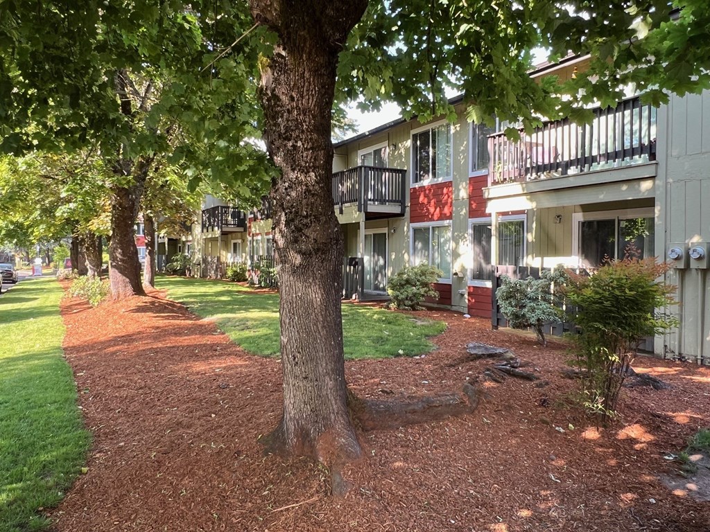 an apartment building with trees and grass in front of it