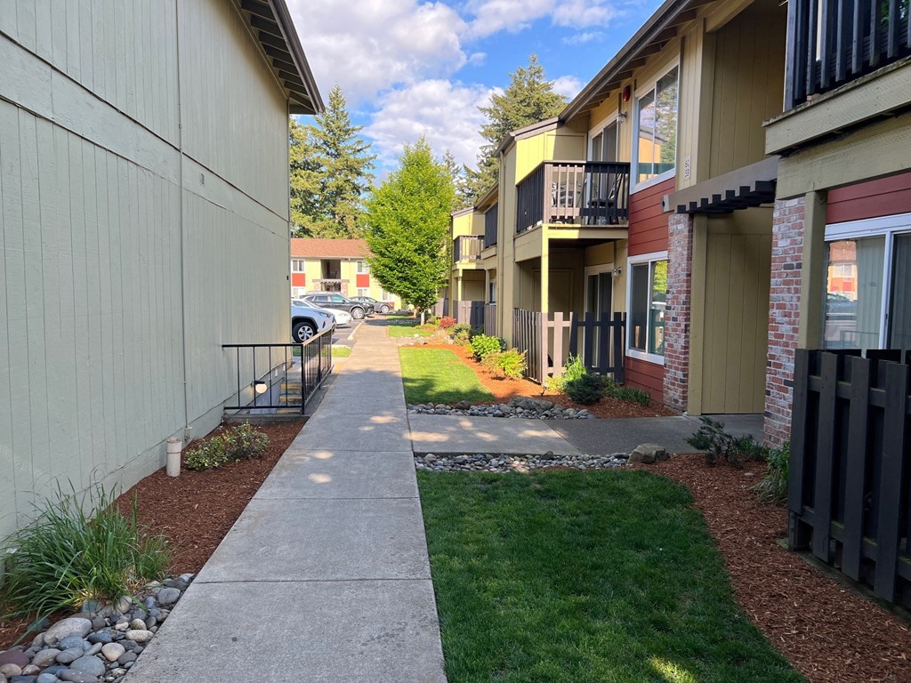a view of a sidewalk in front of some buildings