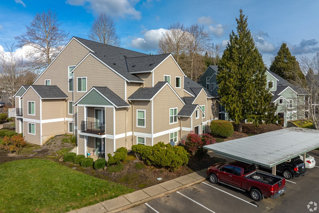 A large apartment complex with a parking lot in front.