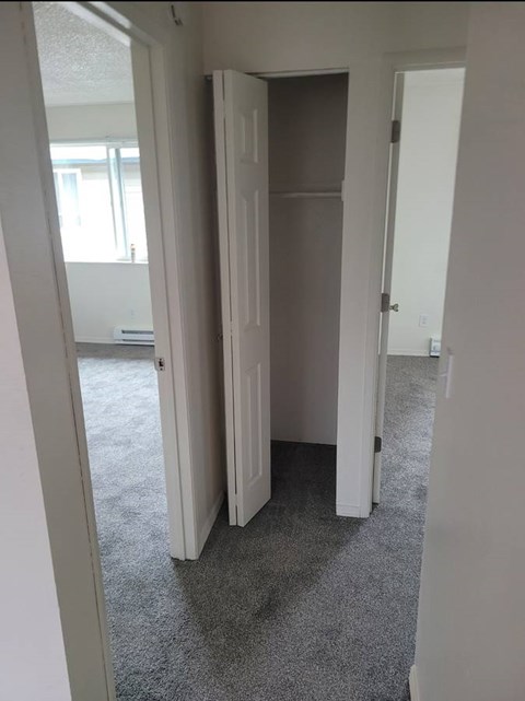 A room with a carpeted floor and a white door.