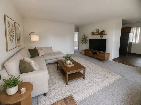 A living room with a couch, coffee table, and television.
