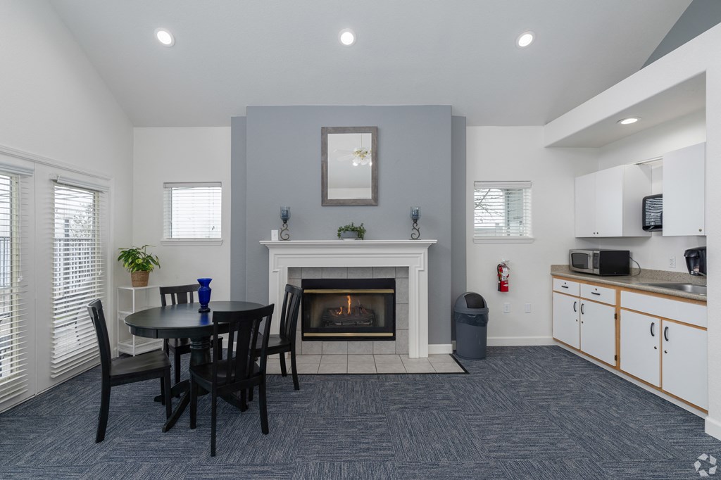 A living room with a fireplace and a dining table.