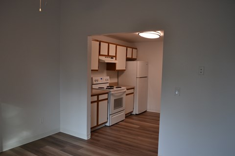 A kitchen with white appliances and wooden cabinets is shown.