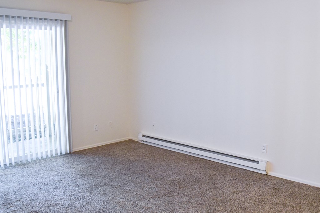 a bedroom with a carpeted floor and a large window