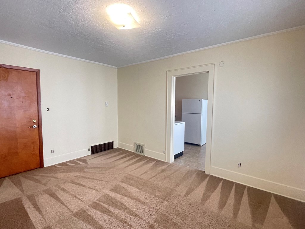 a bedroom with a refrigerator and a door