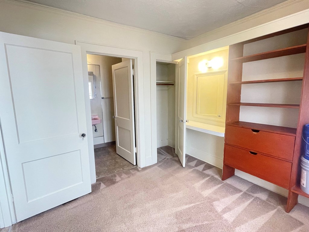 a bedroom with a closet and a dresser