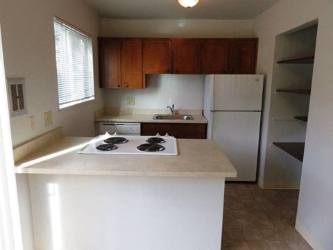 A kitchen with white countertops and a white refrigerator.