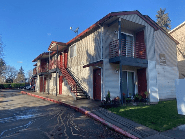 A building with a red awning and a sign that says "Apartments".