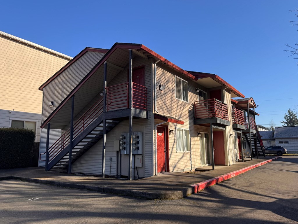A building with a red roof and a staircase leading to the entrance.