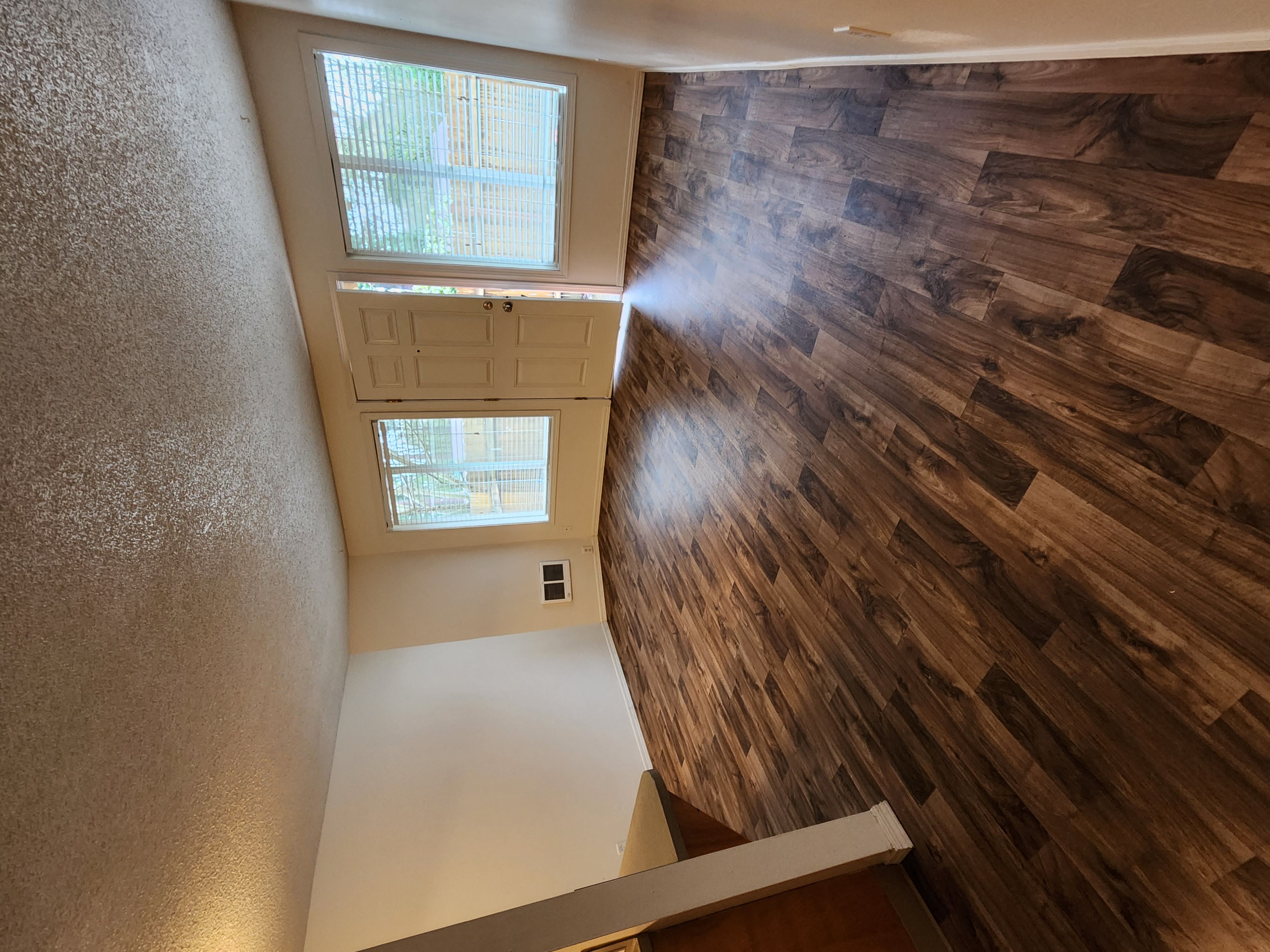 a view from the top of the stairs looking down into the living room