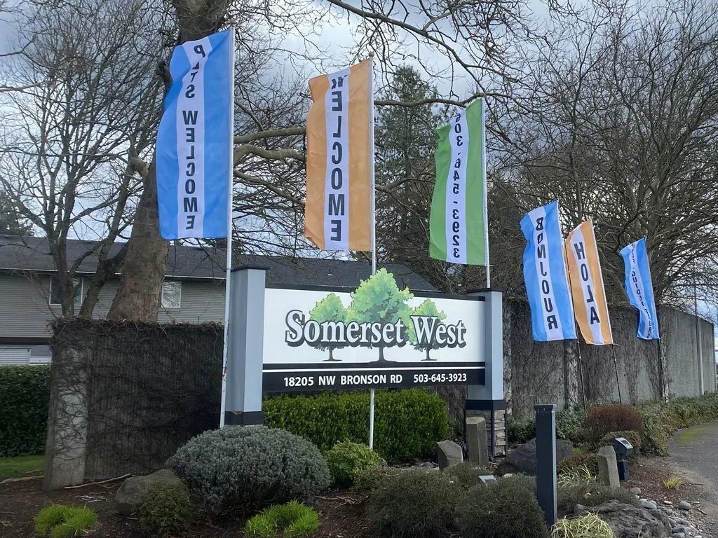 A sign for Somerset West stands in front of a house.