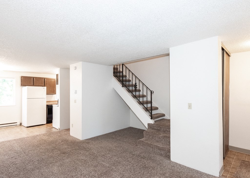 a living room with white walls and a carpeted floor