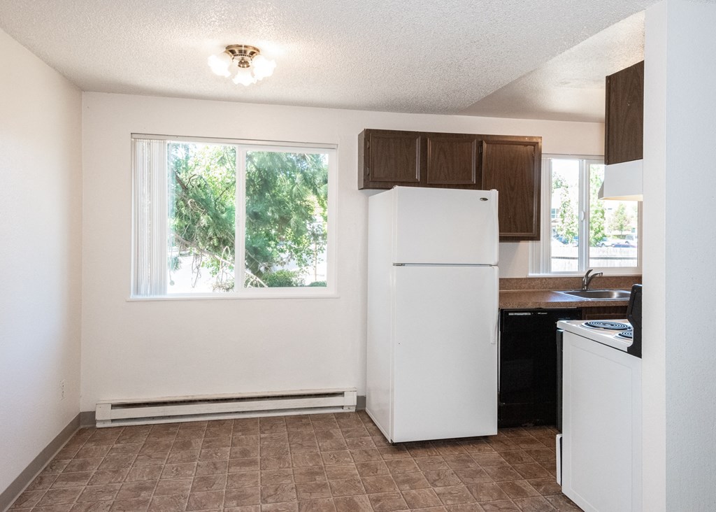 a kitchen with a white refrigerator freezer next to a window