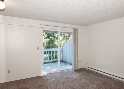an empty living room with sliding glass doors to a balcony