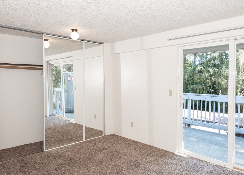 a bedroom with a sliding glass door leading to a balcony
