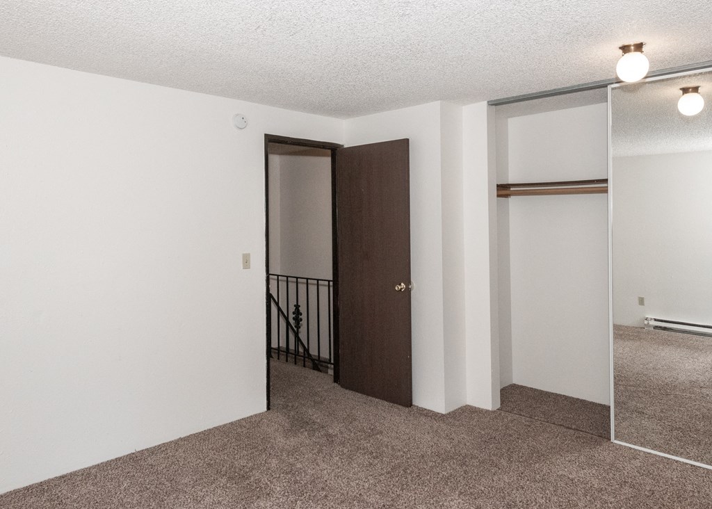 a living room with white walls and a carpeted floor