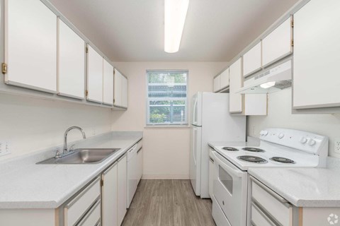 A kitchen with white appliances and cabinets.