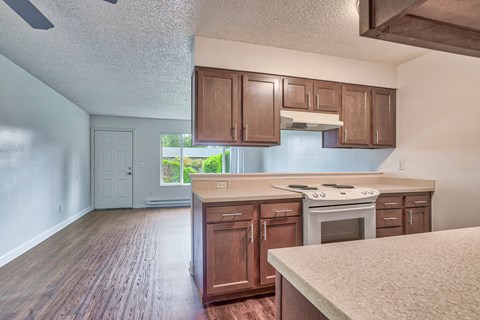 A kitchen with wooden cabinets and a white stove top oven.