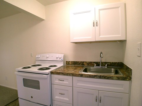 A white stove and sink in a kitchen.