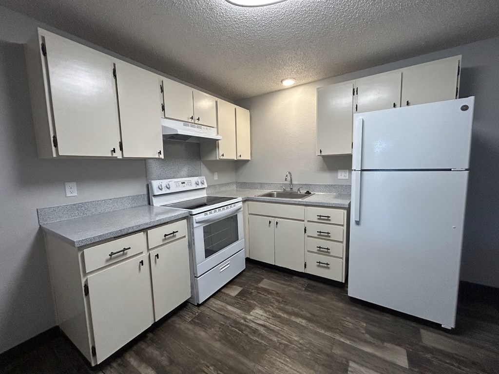 A kitchen with white appliances and cabinets.