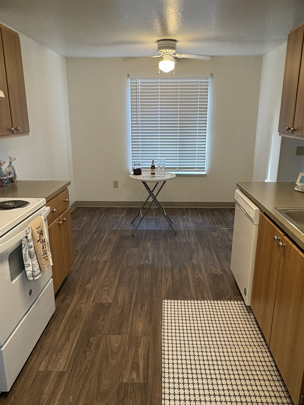 A kitchen with wooden cabinets and a checkered floor mat.