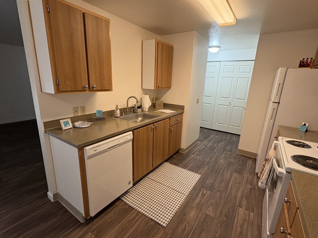 A kitchen with wooden cabinets and a white dishwasher.