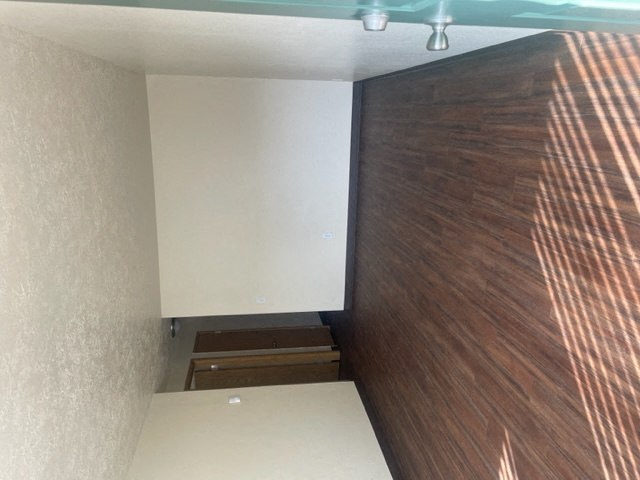 an empty room with a wooden wall and a white floor