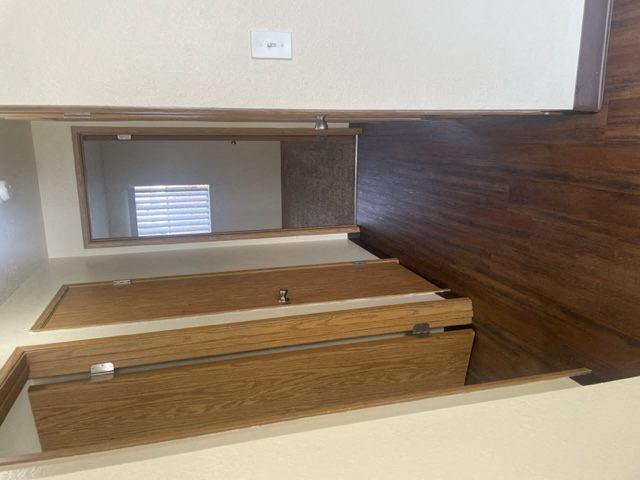 an empty closet with wooden floors and a mirror