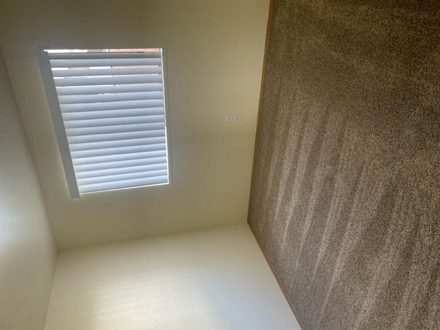 a window in a small room with a brown wall and a white floor