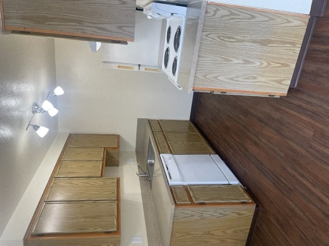 a kitchen with wooden cabinets and drawers and stairs