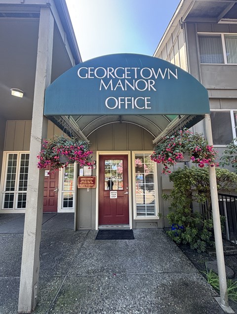 The entrance to the Georgetown Manor Office is adorned with flowers.
