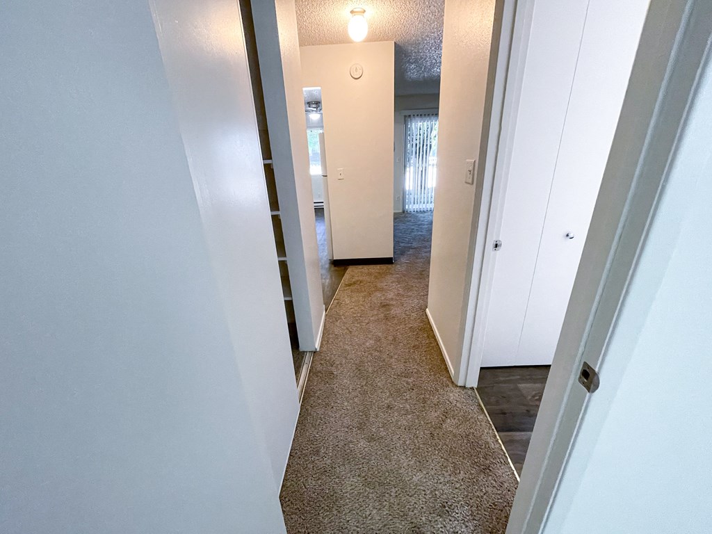 a hallway with a carpeted floor and white walls