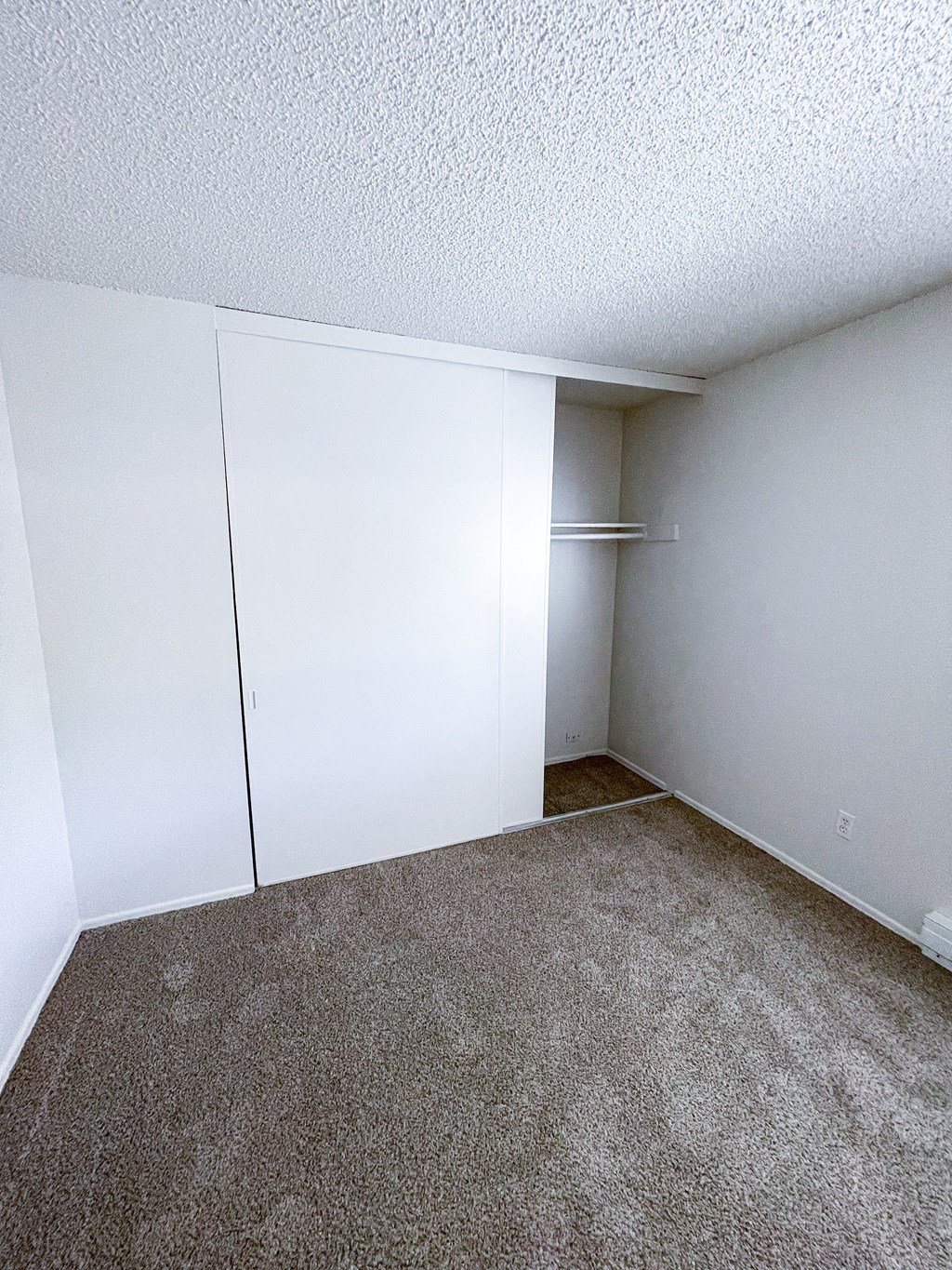 a bedroom with white walls and carpet