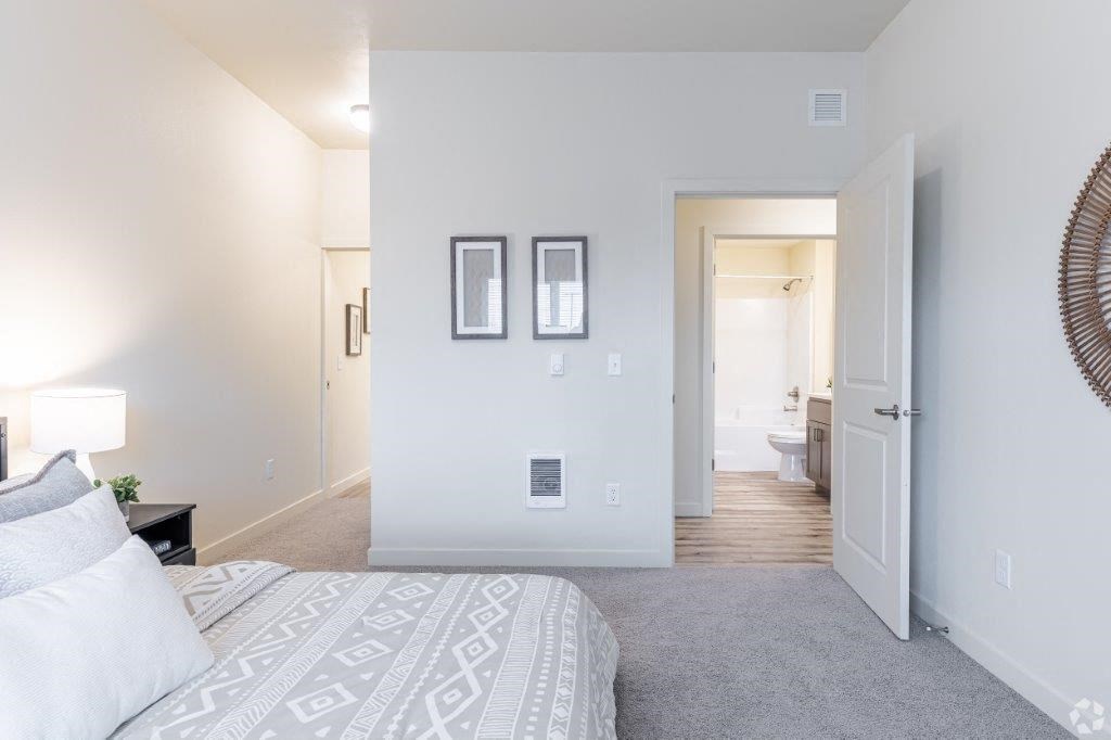 a bedroom with a bed and a door to a bathroom