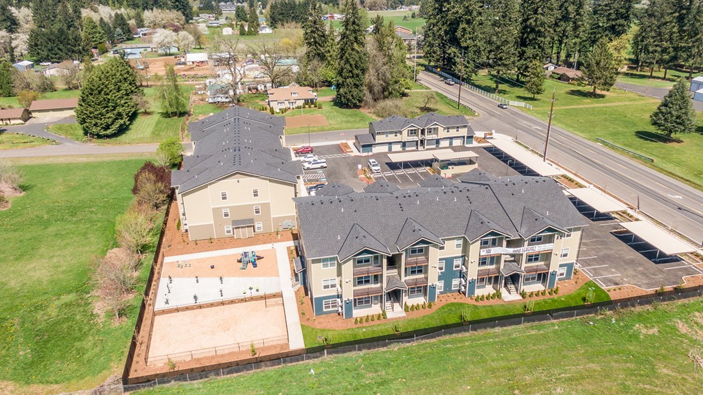 arial view of a large home with a gray roof