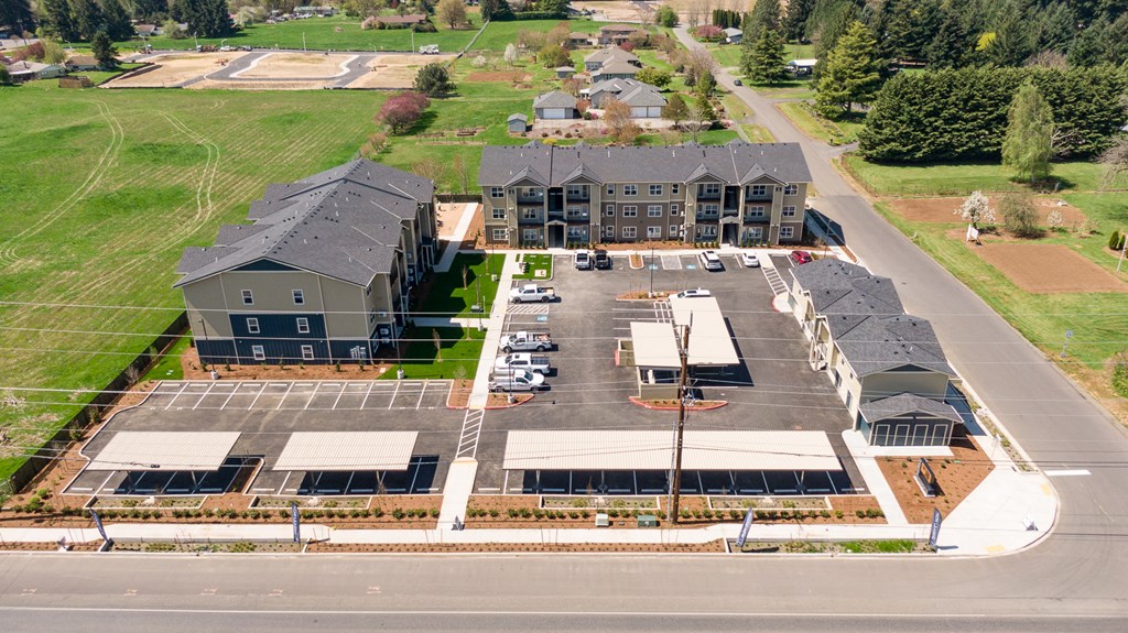an aerial view of an apartment complex with a green field in the background