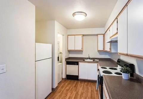 A kitchen with white cabinets and a black stove top.