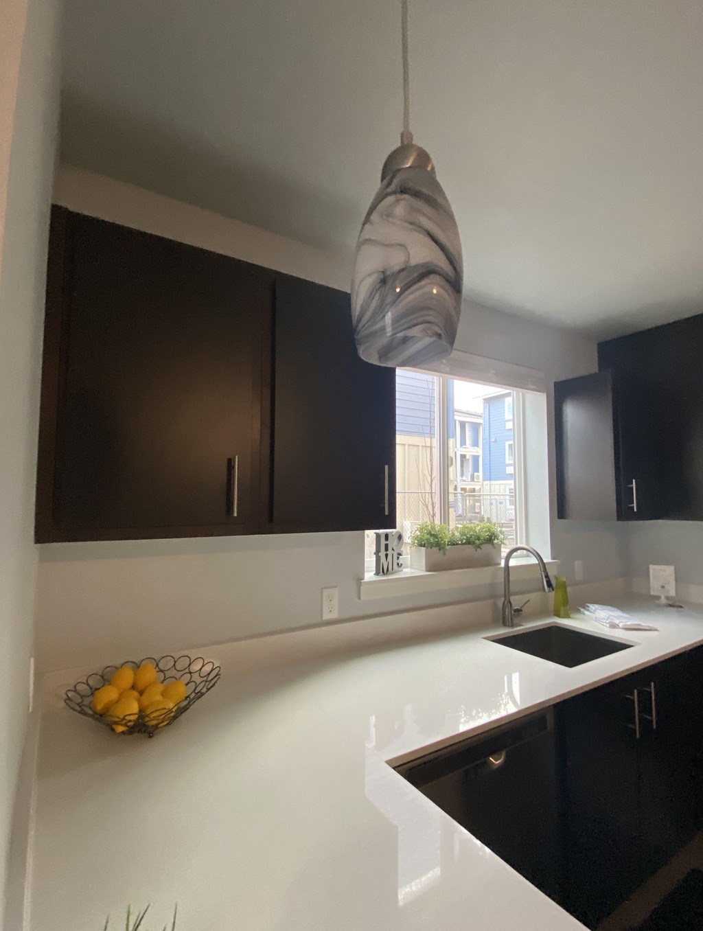 A kitchen with a bowl of lemons on the counter.